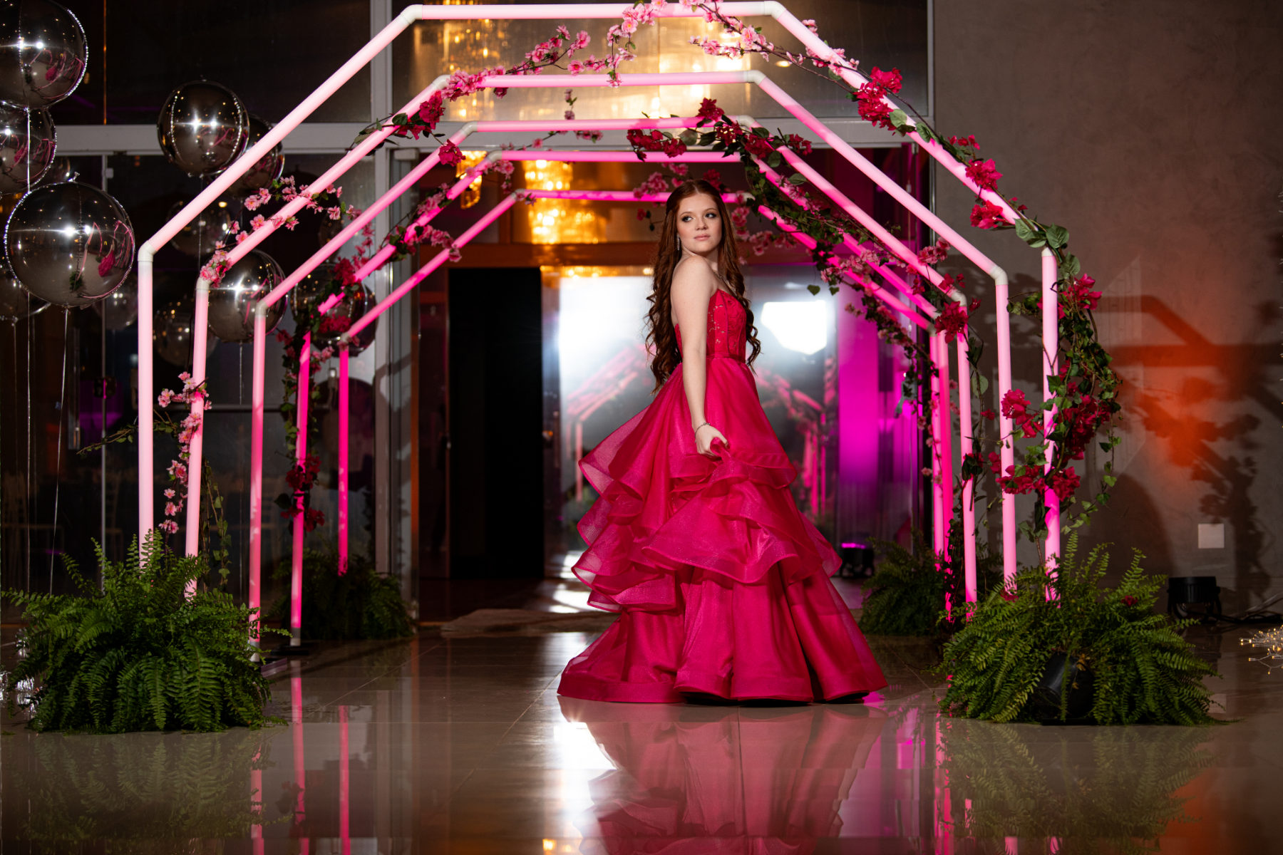 Debutante sob o arco iluminado do salão